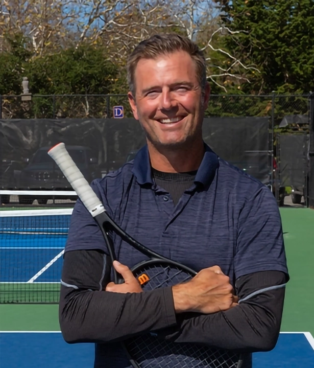Jon Kooy, Tennis Director at CVAC, smiles on a pickleball court while holding a racket