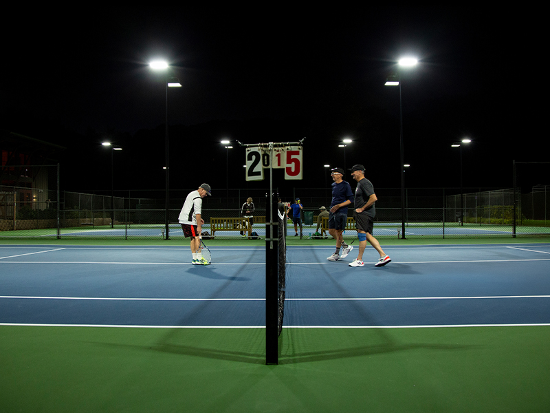 Members playing tennis at CVAC at night.
