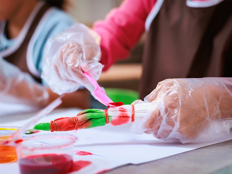 Stock photo of kids making tie-dye shirts.