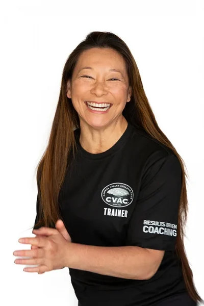 Kimi, Personal Trainer, smiles on a white background